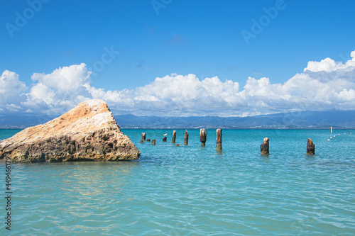 A large triangular rock and the remnants of an old dock in the turquoise water off Isla de Cajo de Muertos, Puerto Rico, USA. photo