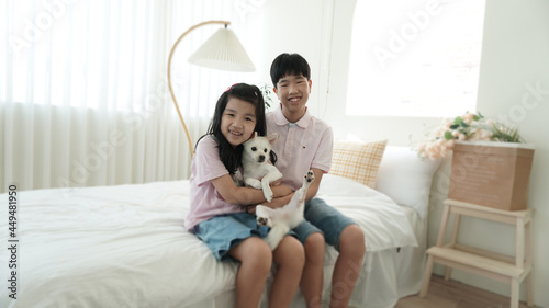 강아지와 집에서 즐거워하는 아이들 Laughing kids on the bed with a dog at home