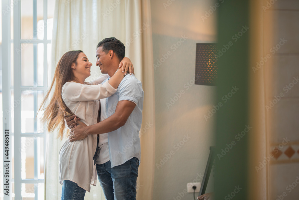 Happy mixed race ethnicity at home feel excited dancing and holding  with fun, smiling overjoyed   couple enjoy celebrating anniversary swirling and dancing together in love relationship