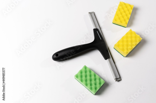 cleaning tools, scraper, window nozzle and colored washcloths on a white background