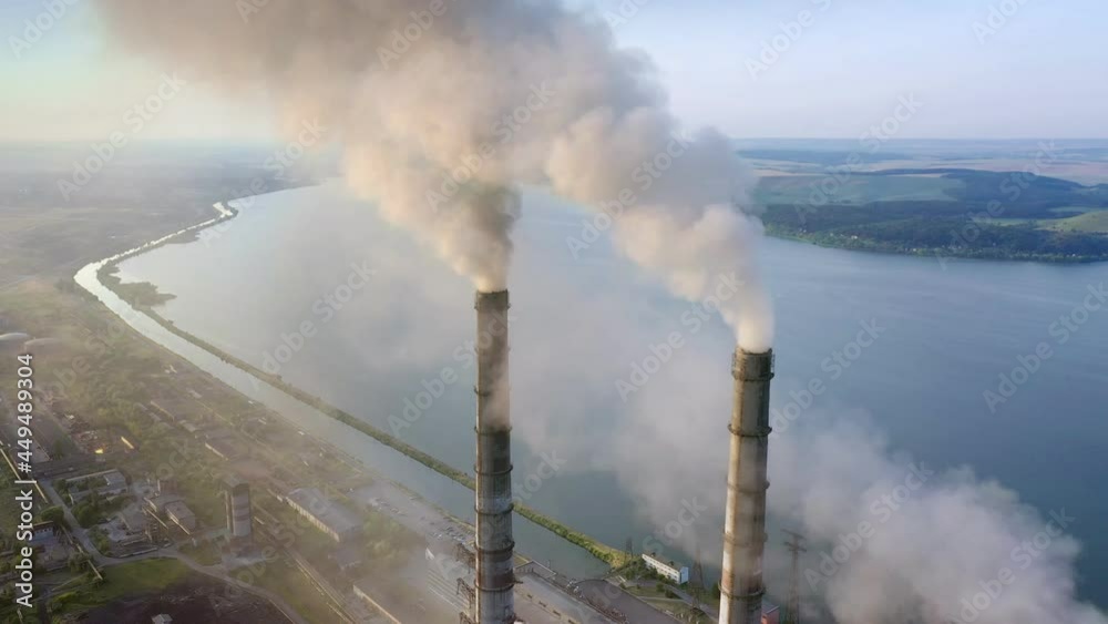 Aerial view of coal power plant high pipes with black smokestack polluting atmosphere. Electricity production with fossil fuel concept