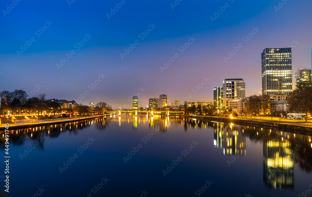 Fototapeta premium Night view of Frankfurt, Germany, with brightly lit buildings reflected in the nice Main River