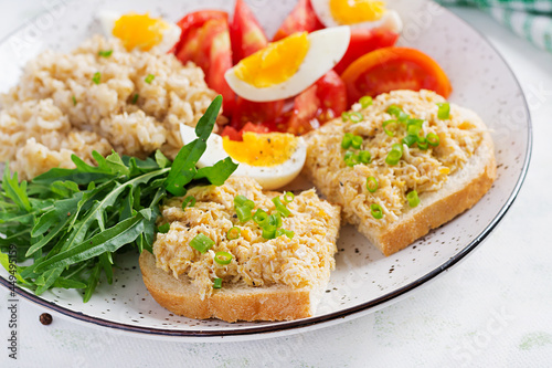 Fresh salad. Breakfast bowl with oatmeal, sandwiches with chicken rillettes, tomato and boiled egg. Healthy food.
