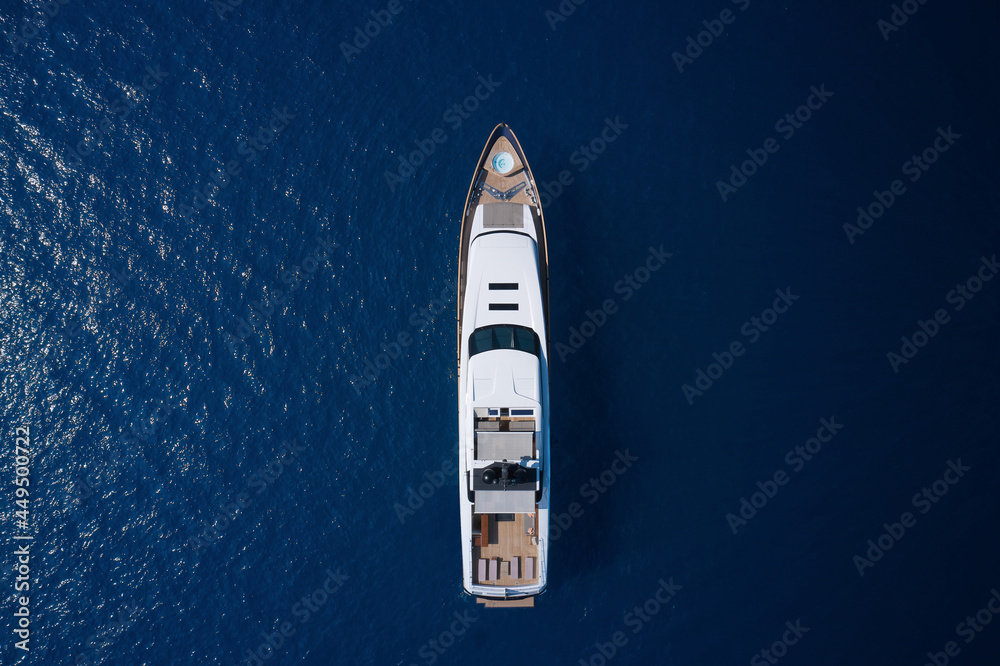 White yacht open sea aerial view. Super yacht on blue water top view. A huge white super Mega yacht on blue water in Italy. White yacht open sea aerial view. Super yacht on blue water top view. A huge white super Mega yacht on blue water in Italy.