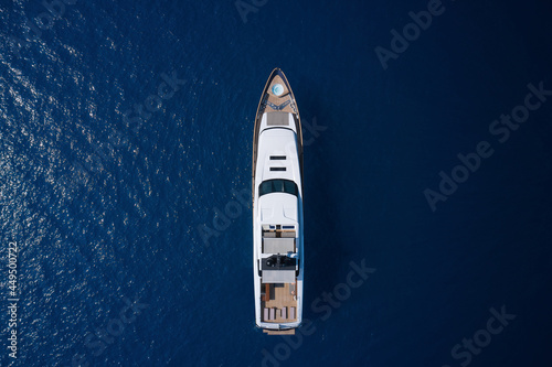 White yacht open sea aerial view. Super yacht on blue water top view. A huge white super Mega yacht on blue water in Italy.
