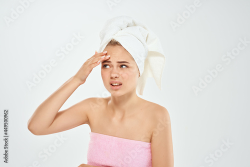 woman with towel on head holding face skin care dermatology health