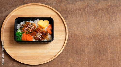 Teriyaki eel over rice on a wooden tray
