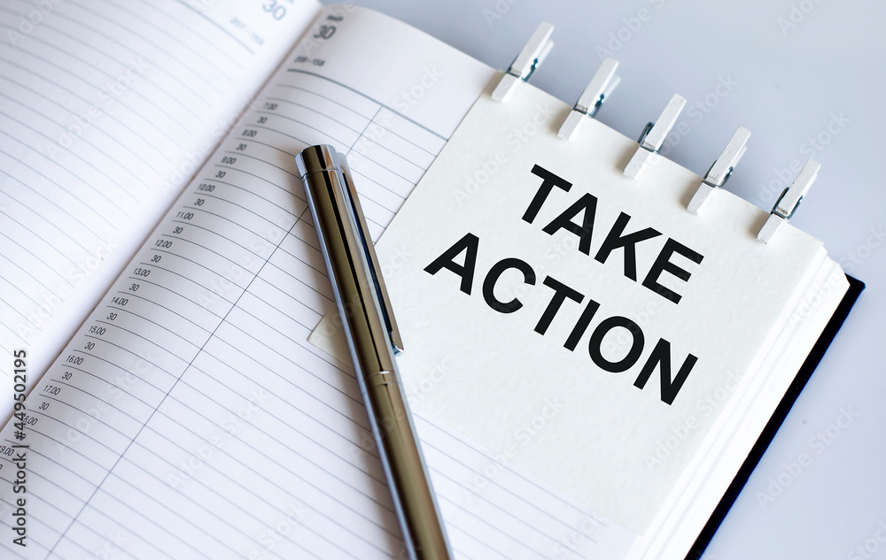 text TAKE ACTION on the short note texture background with pen.Business concept text TAKE ACTION on the short note texture background with pen.Business concept