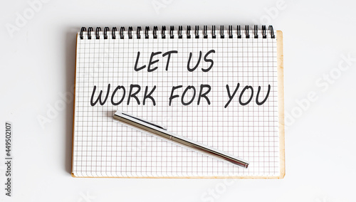 Notebook with pen and Notes about LET US WORK FOR YOU ,business