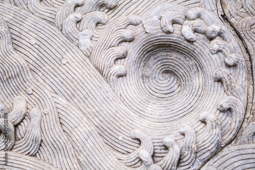 The stone is carved into a wave of water,Close-up of spiral pattern carved in rough stone,golden ratio.