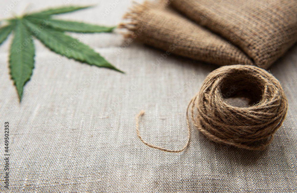 Cannabis leaves on the hemp textile background Cannabis leaves on the hemp textile background