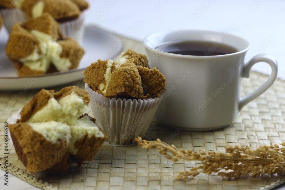 Bolu Kukus Cokelat or Flower bloom steam cake, Indonesian traditional cake, with chocolate flavour. White bright background. Morning tea concept. Bolu Kukus Cokelat or Flower bloom steam cake, Indonesian traditional cake, with chocolate flavour. White bright background. Morning tea concept.