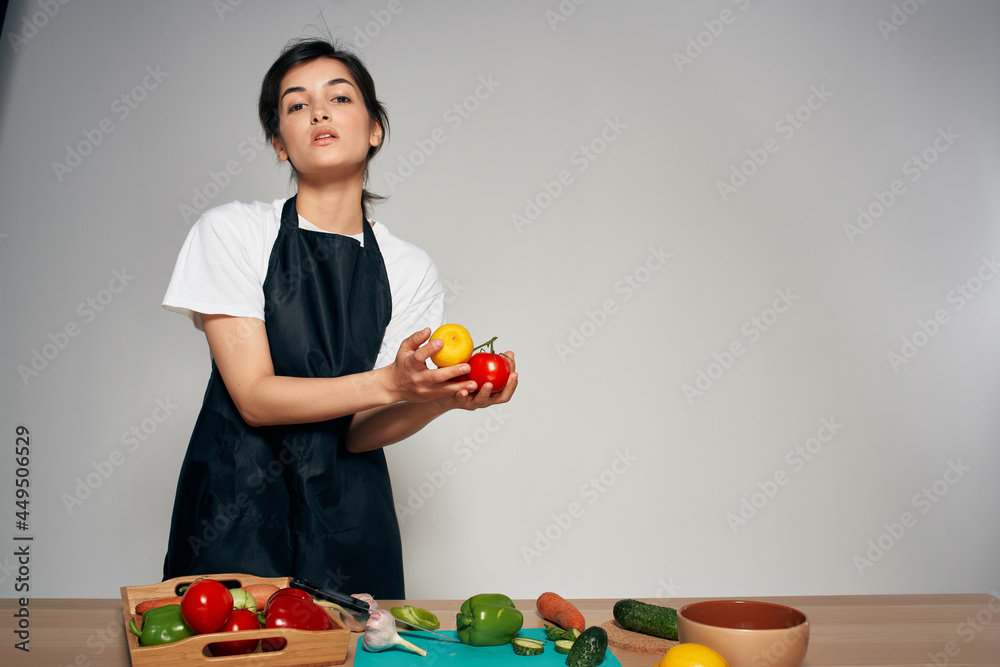 Fototapeta premium cheerful woman in the kitchen housewife cooking vegetables