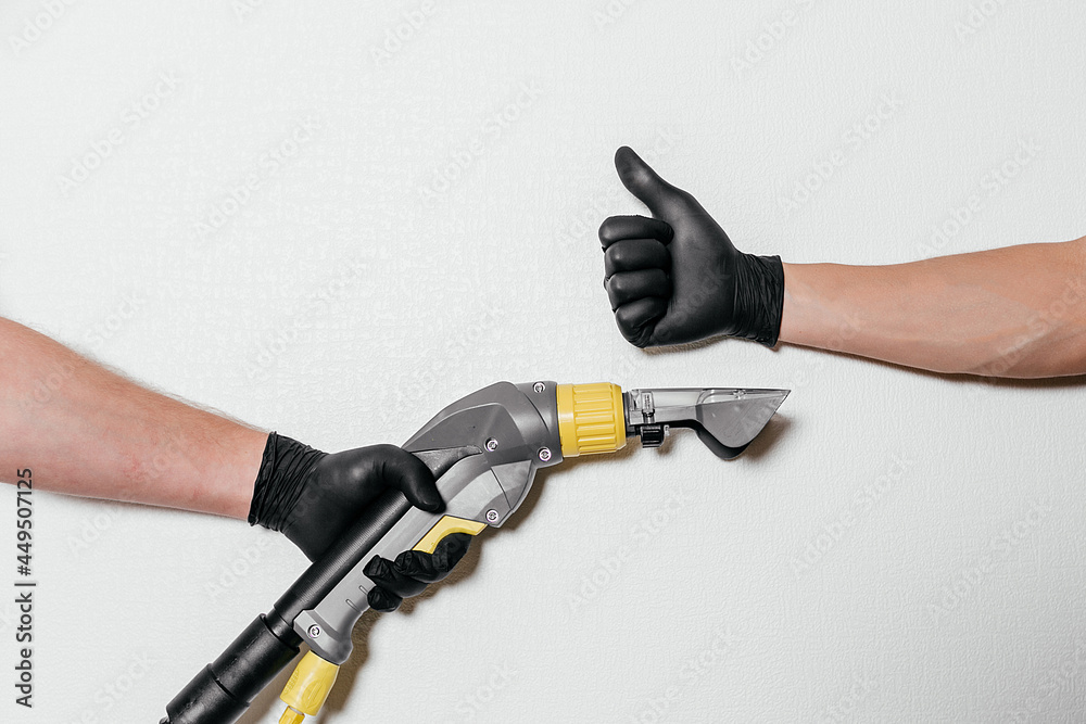 A man's hand on a white background shows the class with his thumb. A man's hand holds a dry cleaning machine. Two male hands A man's hand on a white background shows the class with his thumb. A man's hand holds a dry cleaning machine. Two male hands
