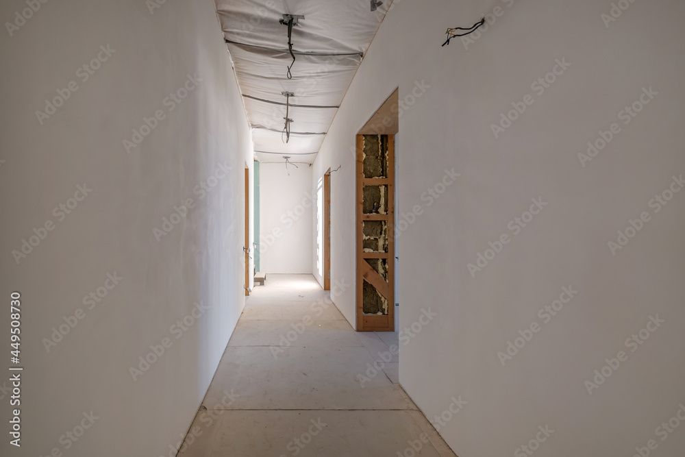 Empty unfurnished corridor room with minimal preparatory repairs. interior with white walls and drywall