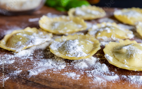 Ravioli with ricotta, spinach and basil prepared for cooking on a wooden board.