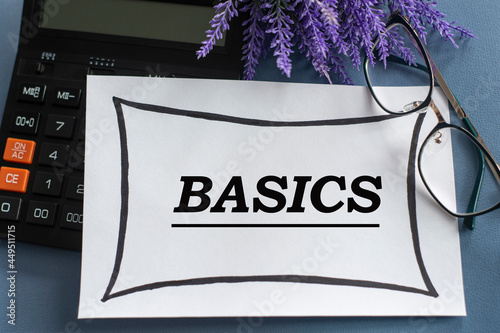 BASICS - word on a white sheet against the background of glasses, pens and lavender photo