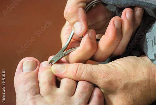 Manicure master trimming cuticles on woman toes with pedicure scissors  cutters.
