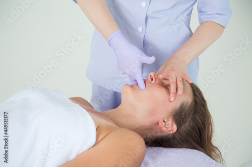 Professional buccal or internal massage of the girl's face photo