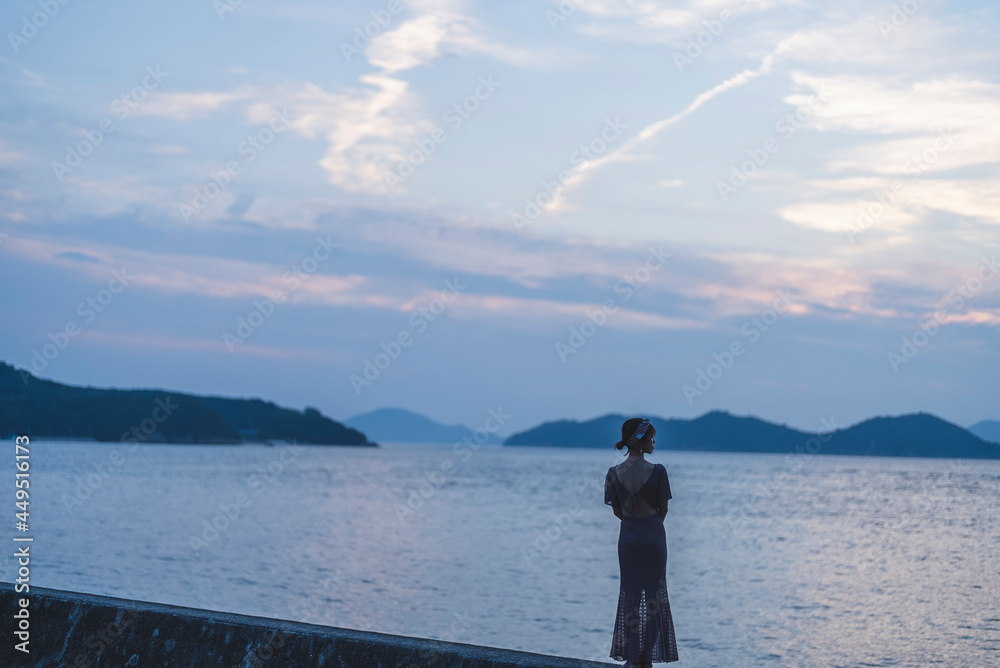 夕暮れの海にいる女性