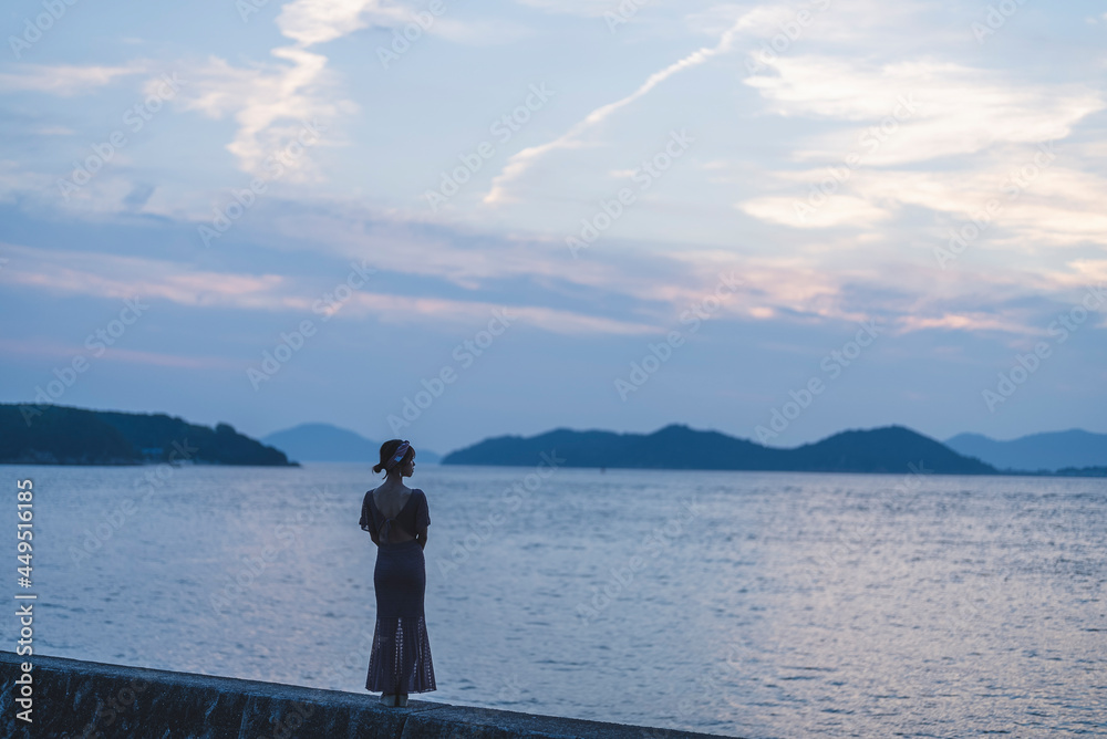 夕暮れの海にいる女性