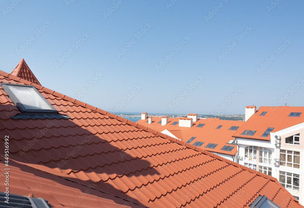 view of the roof of houses from the skylight, background blue sky and the sea in the distance, resort.