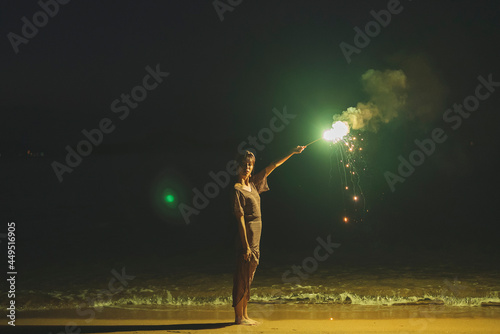 夕暮れの海で花火をする女性 © peach100