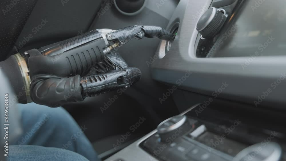 Humanoid robot driver starts or stops engine of car, presses ignition button with his finger closeup. Humanoid robot driver starts or stops engine of car, presses ignition button with his finger closeup.