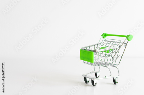 Shopping cart on white background. Small miniature shop trolley with space for your text. Copyspace mock up banner