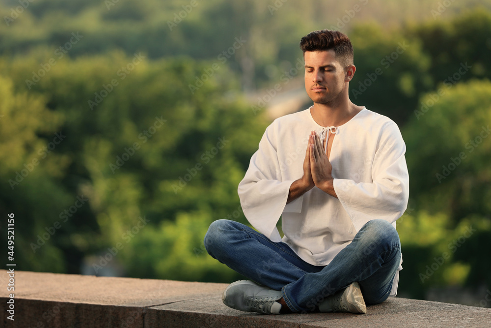 Man meditating outdoors on summer day. Space for text Man meditating outdoors on summer day. Space for text
