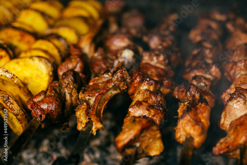 potatoes and shish kebab are fried on the grill