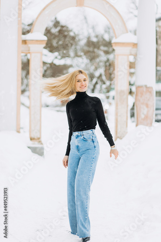 Close-up winter portrait of young woman with blond hair in the park