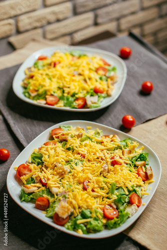 caesar salad on a plate with red tomatoes