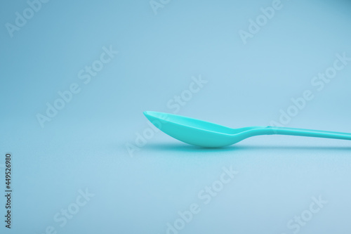 Blue plastic spoon on blue background