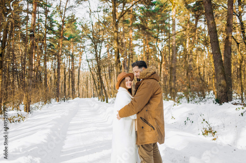 Family walks with pine forest in winter..Husband and wife hug each other.