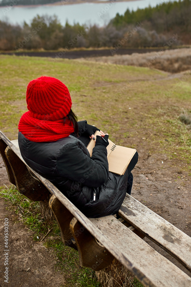 Travel woman with red hat in black jacket write on notebook, make notes