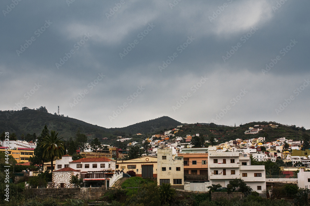 Scenic view on volcanic mountain valley and typical house facades of historical town Teror in Gran Canaria (Province of Las Palmas, Canary Islands, Spain). Moody panoramic countryside landscape.