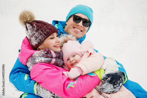 Family in winter clothes having fun, rejoice in the snowdrifts