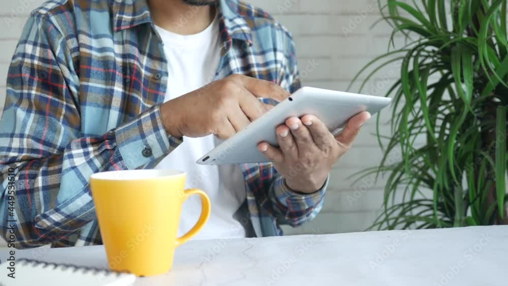 Young man working on digital tablet at office desk, Young man working on digital tablet at office desk,