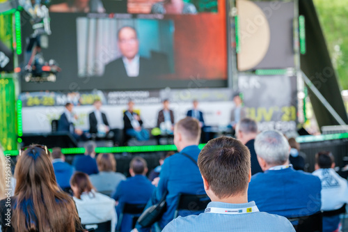 Participants of open air conference listening to speaker