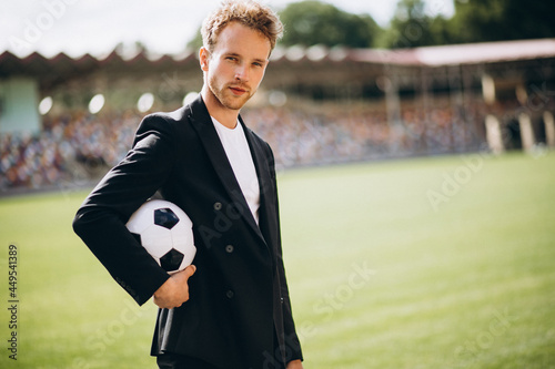 Handsome football player at stadium in business suit photo