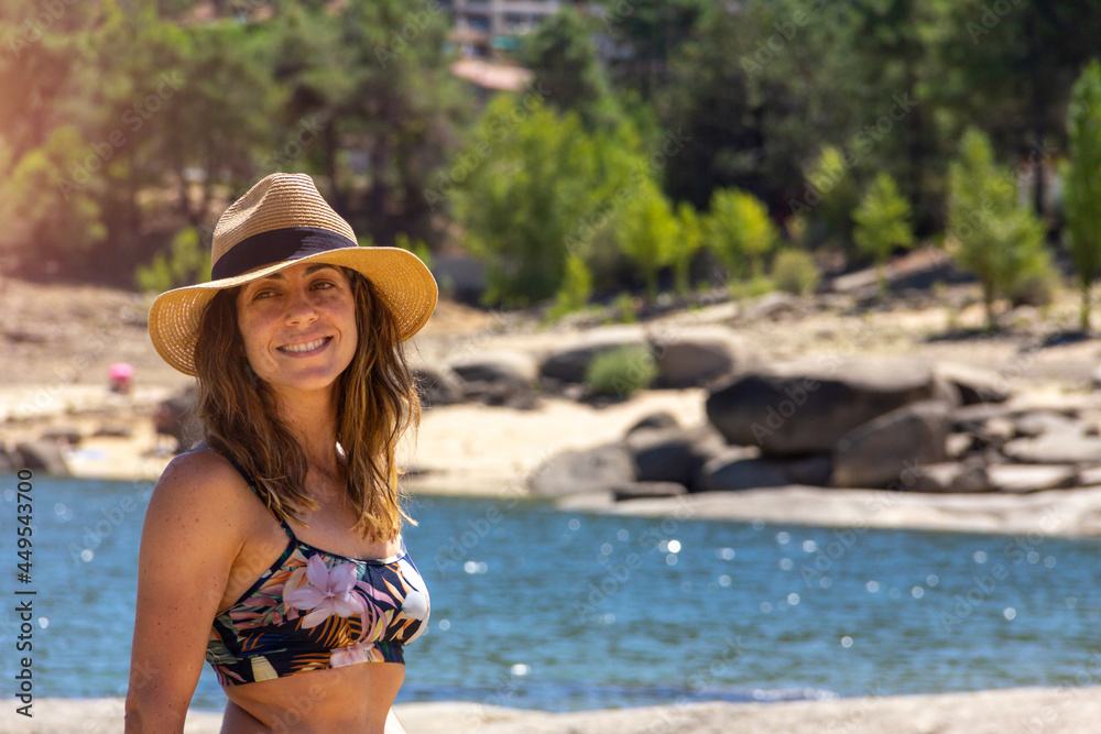 Young woman posing in a bikini with a hat in a lake. Selective focus. Leisure.
