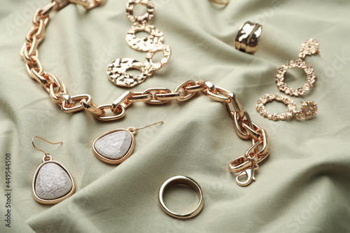 Stylish golden bijouterie on light olive fabric