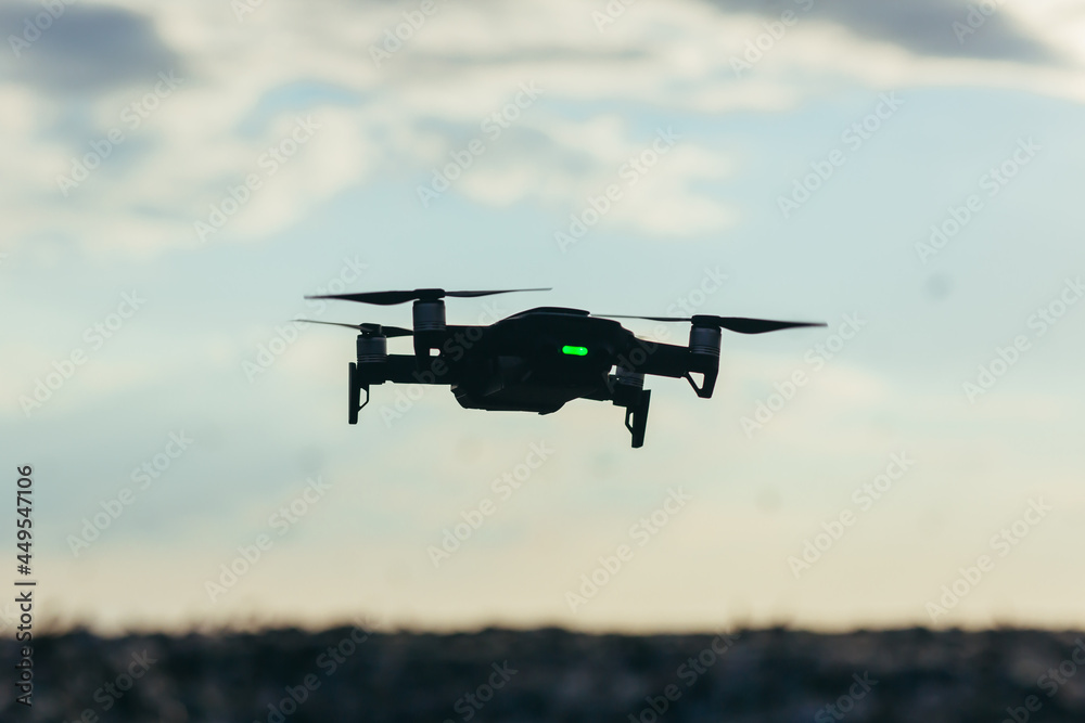 Drone silhouette on sky background with sunset Drone silhouette on sky background with sunset