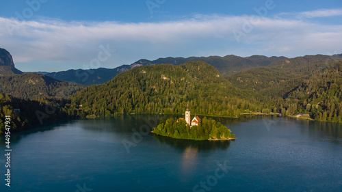 View of beautiful Lake Bled (Blejsko Jezero) with the Pilgrimage Church of the Assumption of Maria on a small island and Bled Castle and Julian Alps at backgroud at summer time.