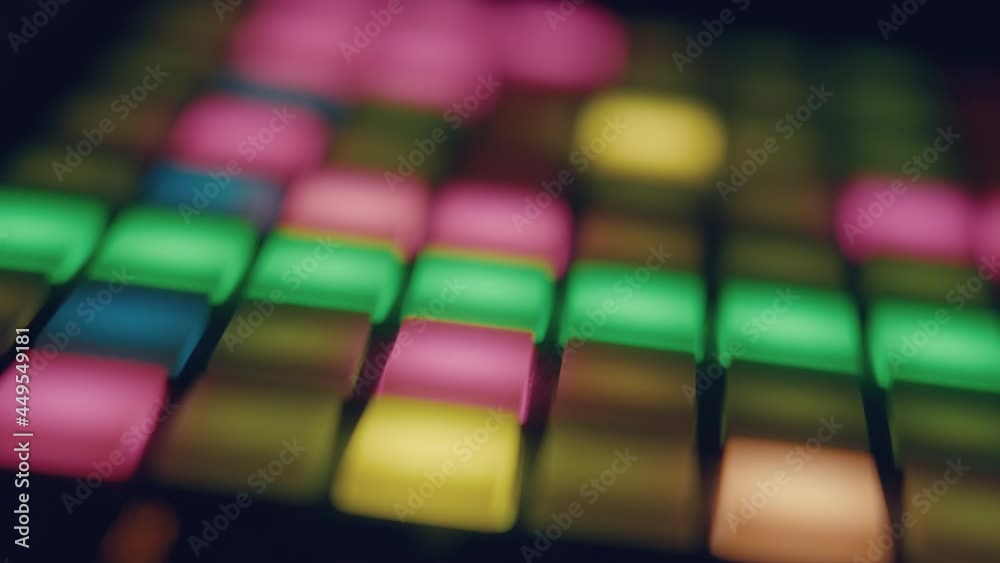 musician playing with Synthesizer grid pad
Close-up of a synthesizer pad, showing a grid with a running timeline. The musician plays the pads and changes the notes of the grid