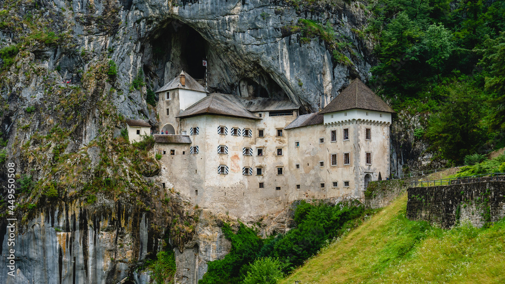 Scenic view of Predjama castle at the cave mouth near Postojna, Slovenia at rainy summer day