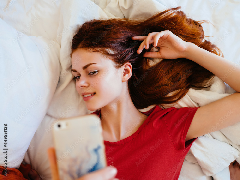 Fototapeta premium pretty woman lying on bed with phone rest chatting at home