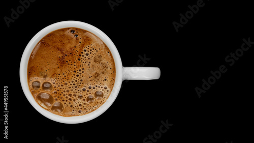 Hot black coffee in white cup on black background, top view