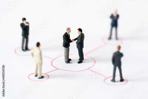Miniature businessman shake hand partner client customers on organization sign with success dealing business using as contract commitment agreement investment and partnership business development join